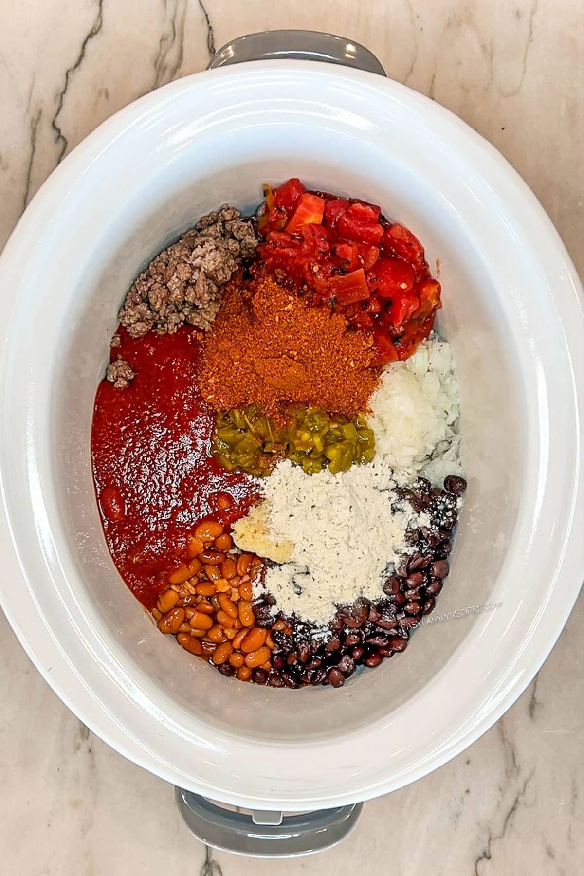 Spices added to the taco chili ingredients in a crockpot.