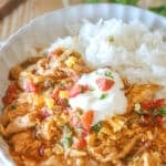 Crockpot Enchilada Chicken Casserole with a side of rice on a white dish.
