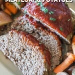 Crockpot meatloaf sliced on a white platter- with baby carrots and new potatoes