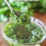 a spoonful of chimichurri sauce being lifted out of a bowl.