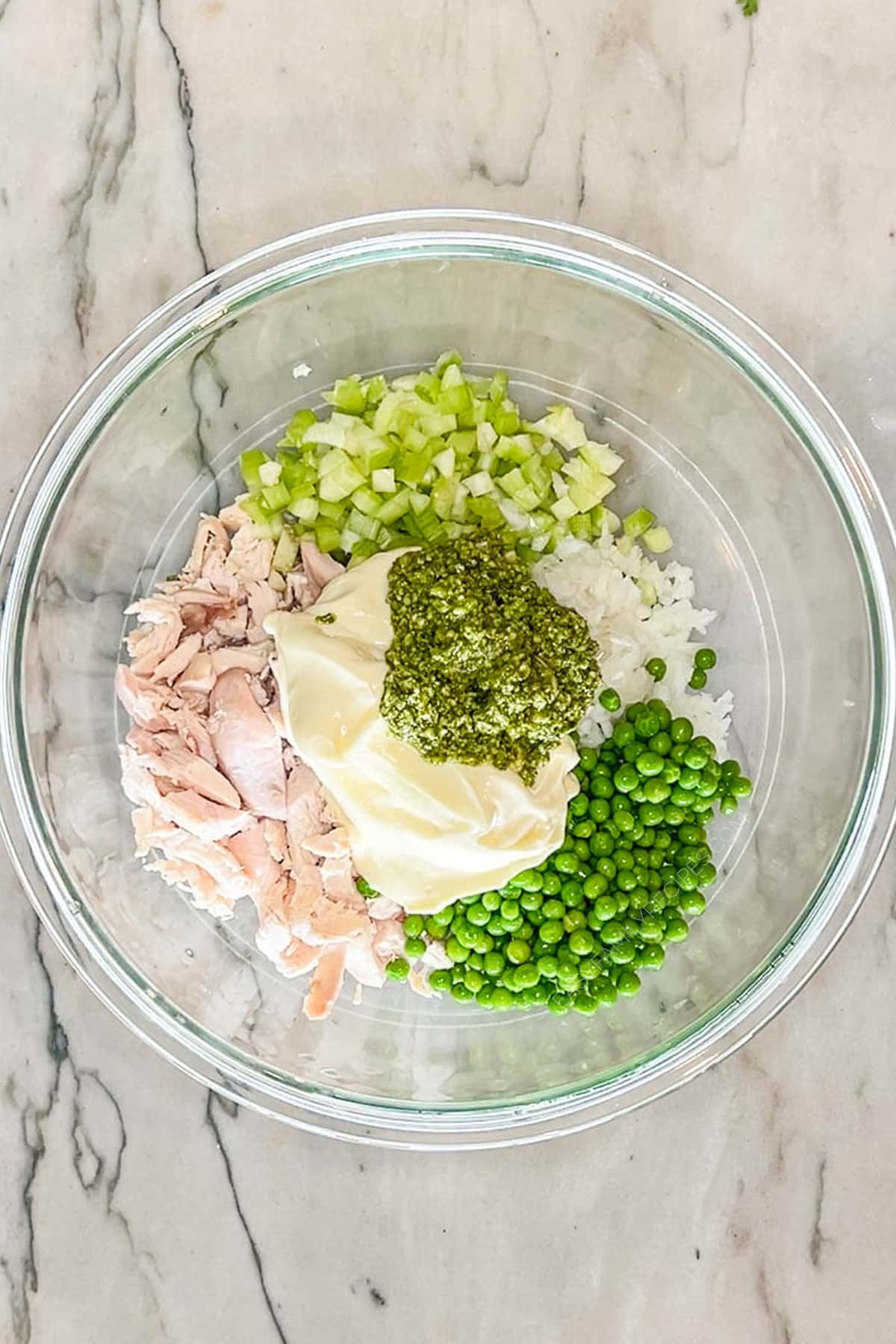 Step one for making pesto chicken salad- add chicken, celery, onion, peas, mayo and pesto to a bowl