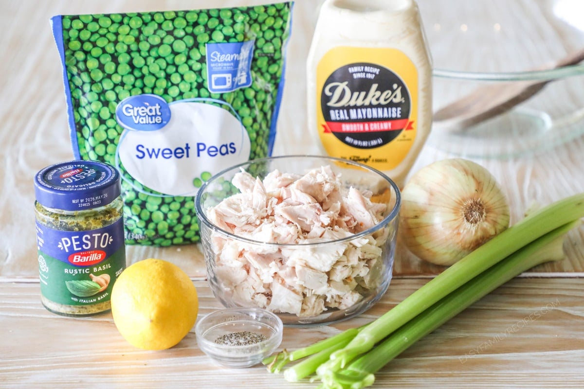 ingredients needed to make pesto chicken salad- on a wooden background