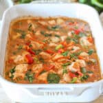 Side view of baked chicken curry in a baking dish with cilantro on top.