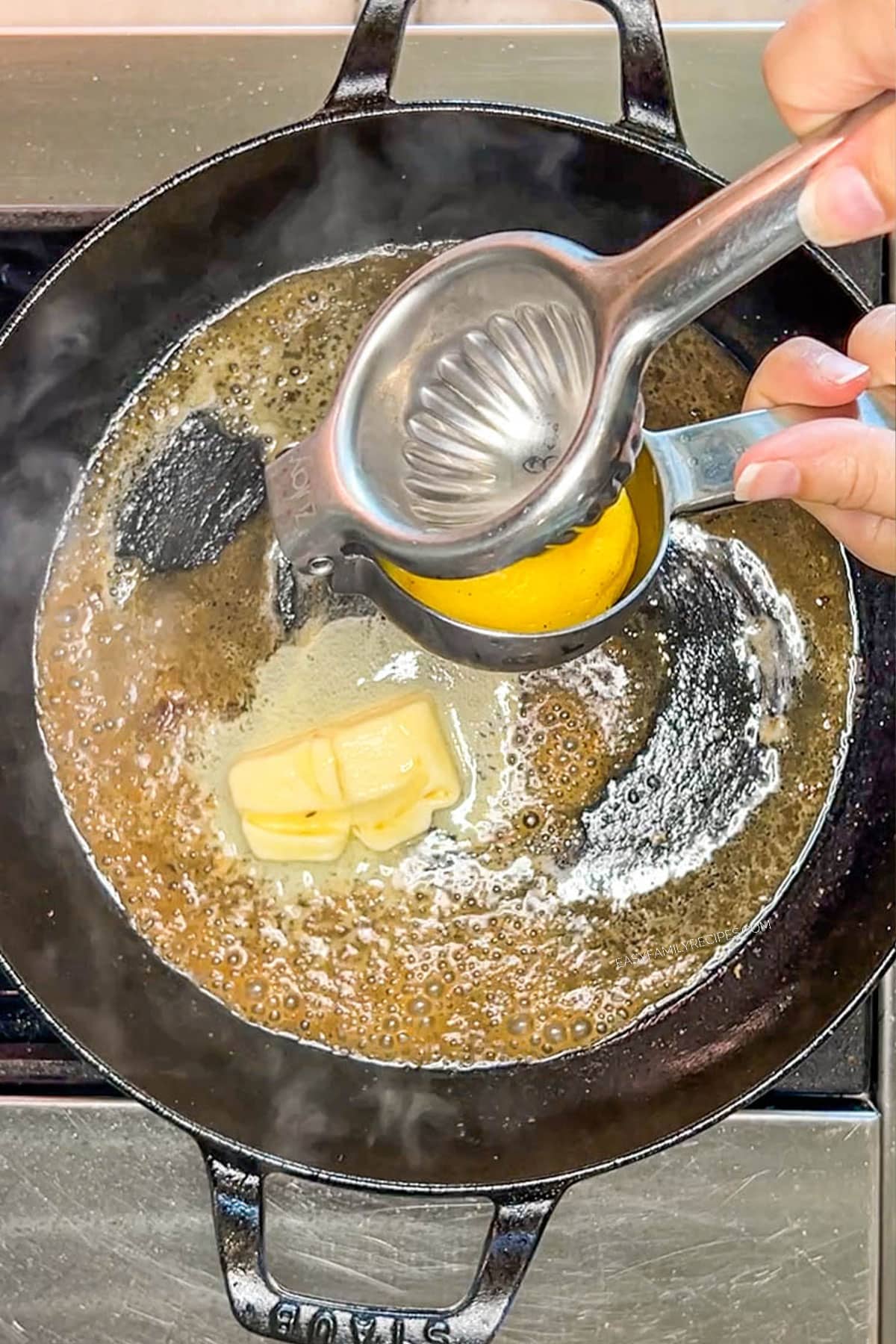 Squeezing lemon into a skillet with butter.