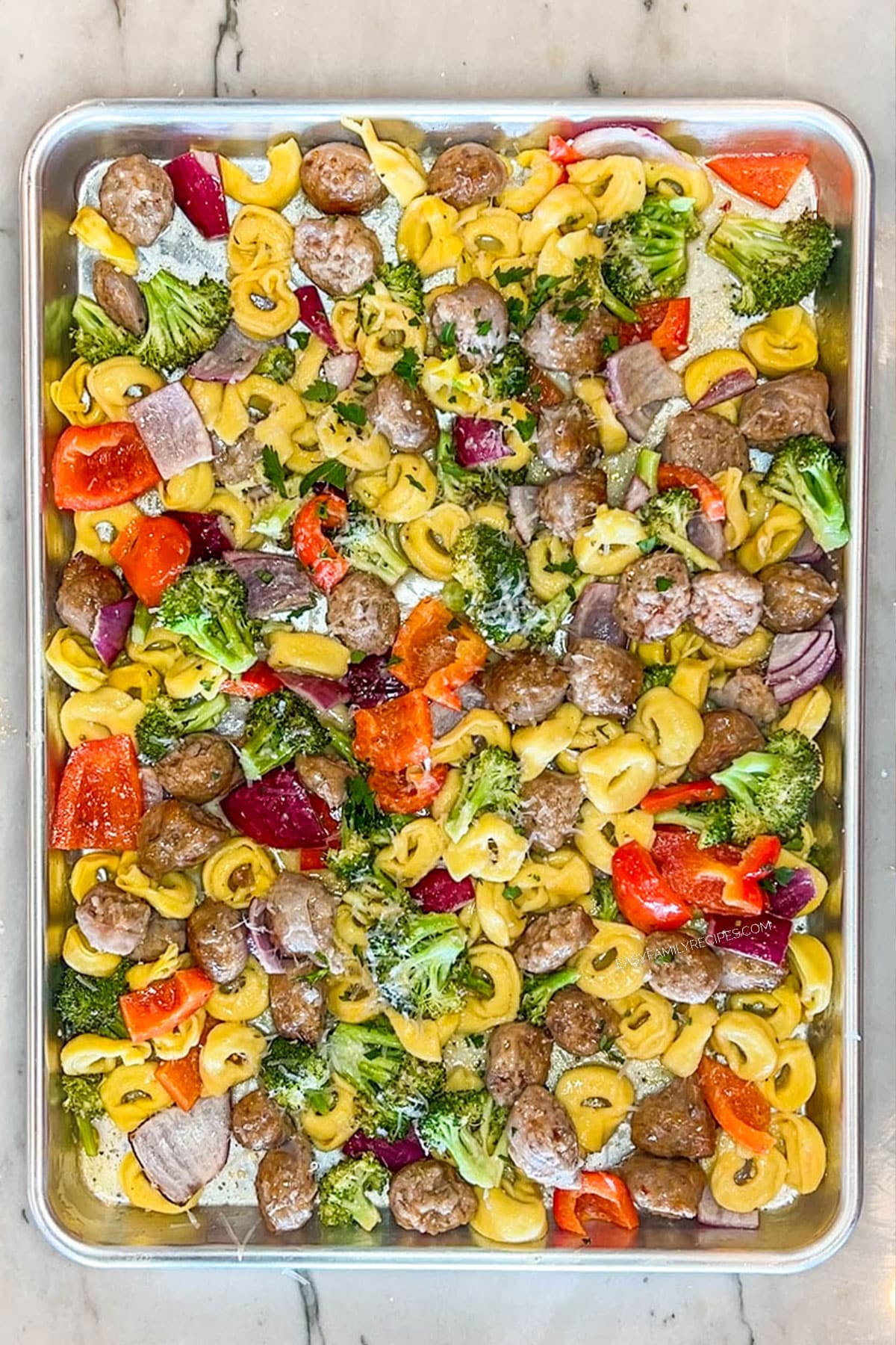 Step 4 to make Sheet Pan Italian Sausage Tortellini- all ingredients cooked together on baking pan
