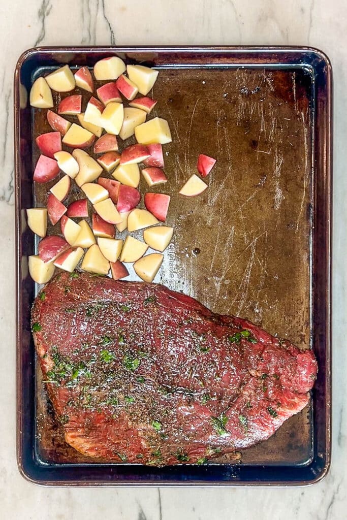 potatoes and steak on a sheet pan.