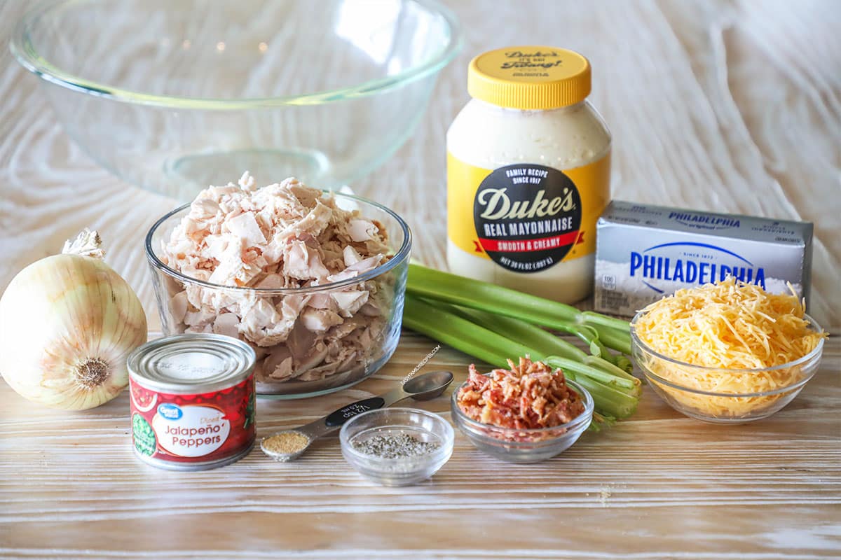 Ingredients needed to make Jalapeño Popper Chicken Salad. On a wooden background.