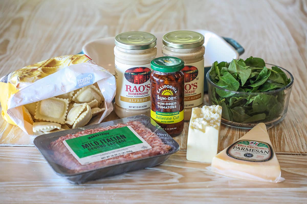 Ingredients needed to make Marry Me Baked Ravioli Casserole. On a wooden background
