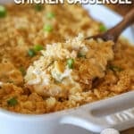 Neiman Marcus Chicken Casserole in white baking dish with wooden spoon lifting out