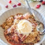Apple cranberry crumble served in a bowl with ice cream on top.