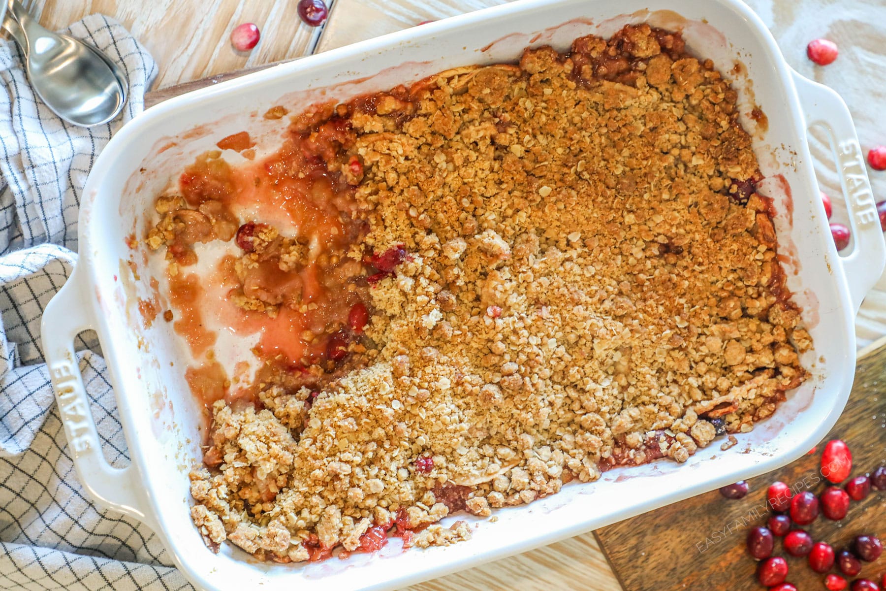 Overhead shot of apple cranberry crumble with a portion missing.