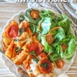 Baked pepperoni rigatoni with hot honey drizzle served on a plate with a side salad.