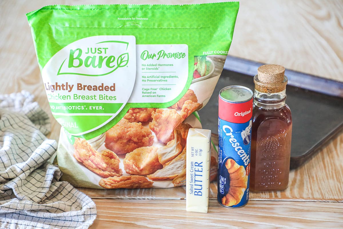 Ingredients needed to make Chicks in a Blanket Recipe. On a wooden background, with a sheet pan and kitchen towel