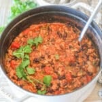 White pot of Chipotle Black Bean Ground Turkey Chili with a spoon