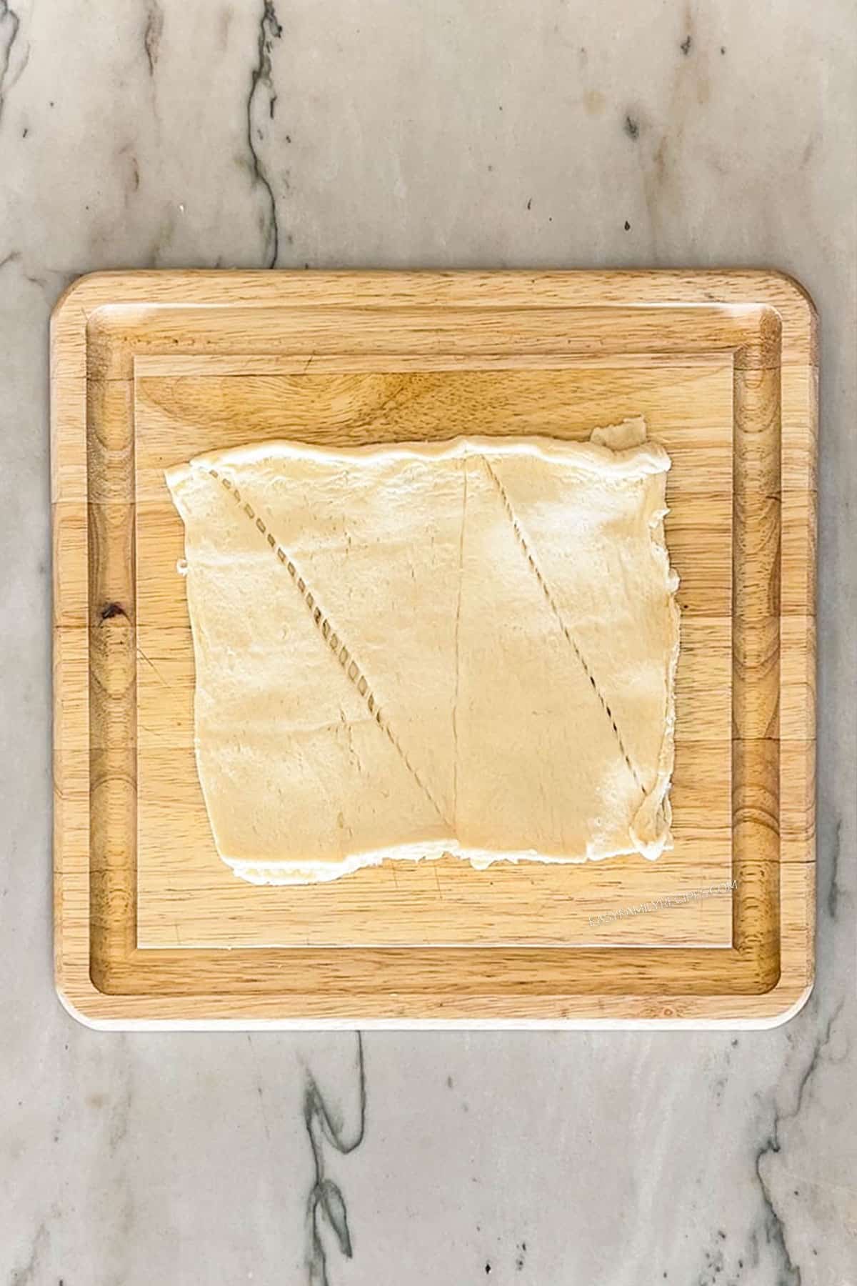 Step 1 for making Chicks in a Blanket. Unroll crescent rolls into flat sheet