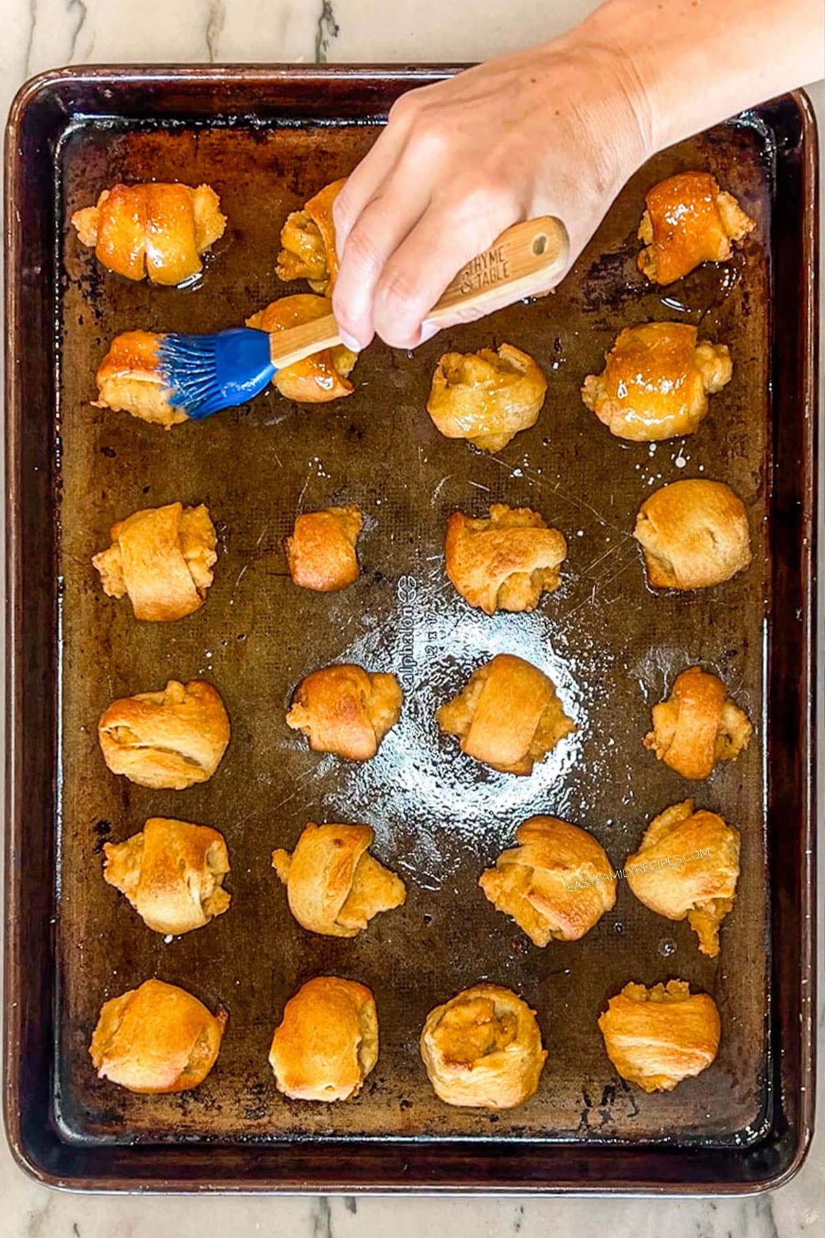 Step 6 for making Chicks in a Blanket. Brush the top of each cooked crescent wrapped nugget with honey butter mixture.