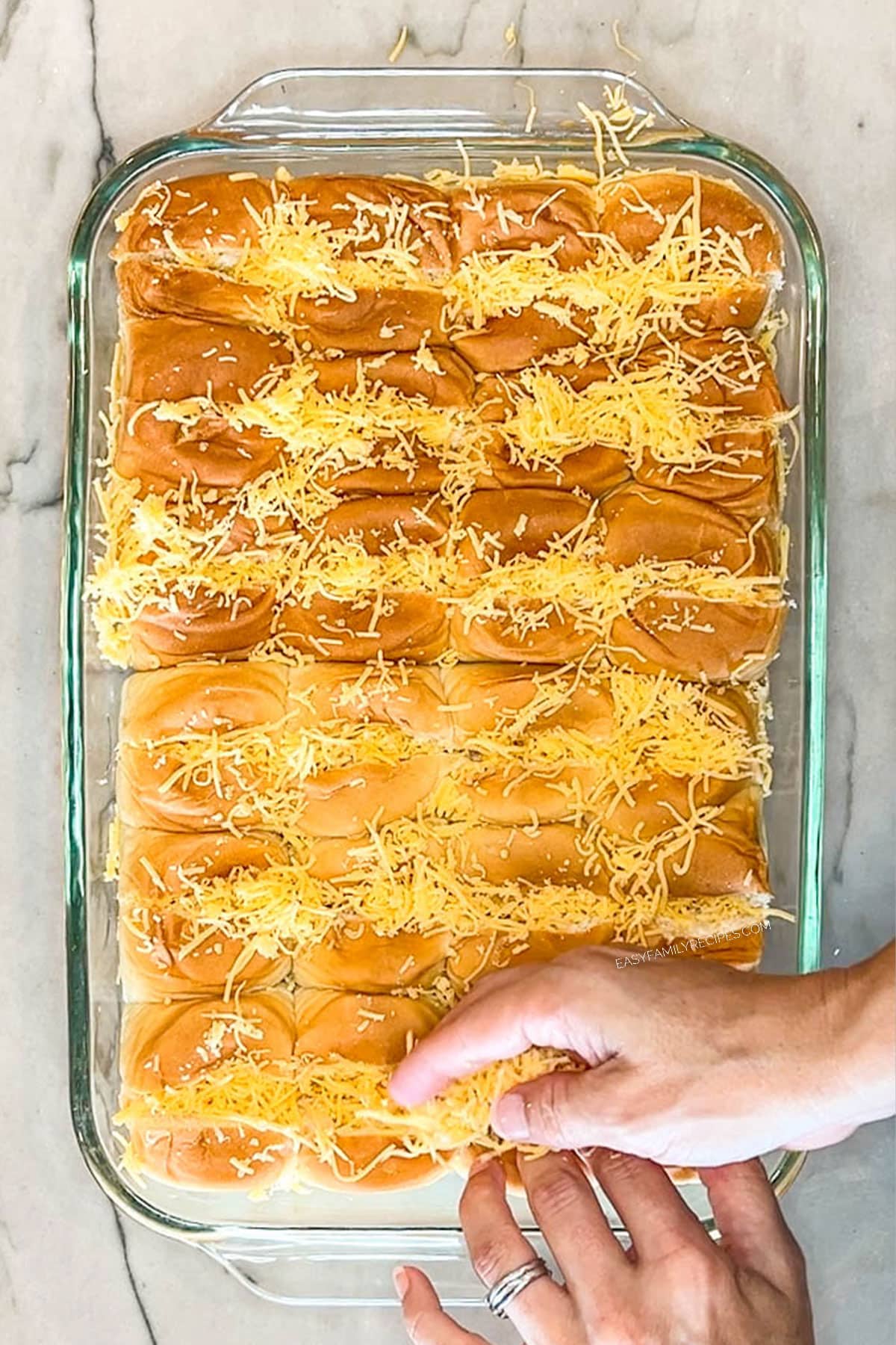 Step 2 for making Chili Dog Sliders. Stuff rolls with shredded cheese