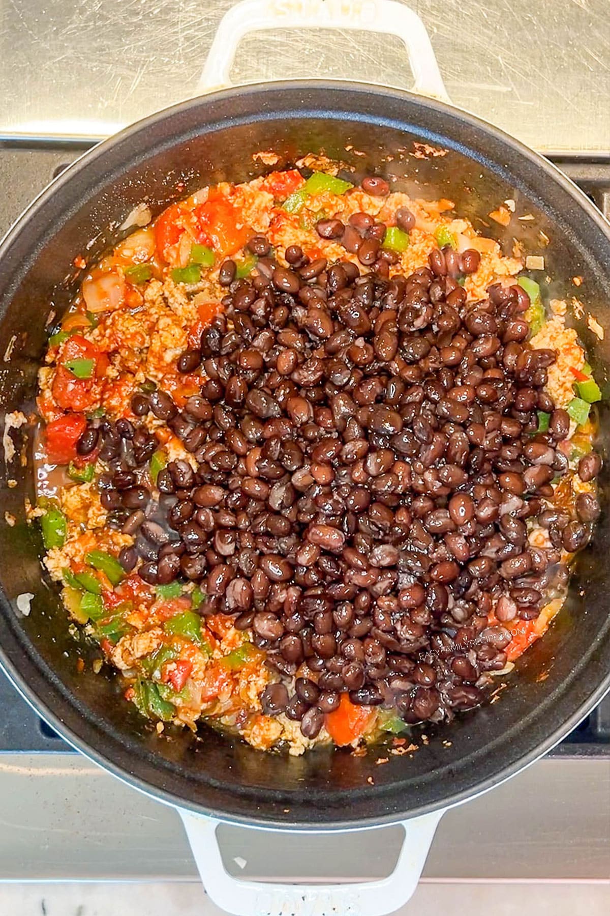 Step 5 for making Chipotle Black Bean Ground Turkey Chili- add black beans and chicken broth