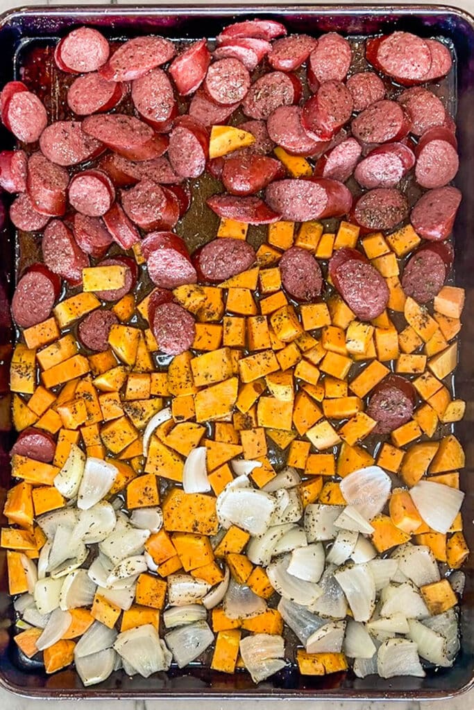 Sausage, sweet potatoes, and onions on sheet pan.