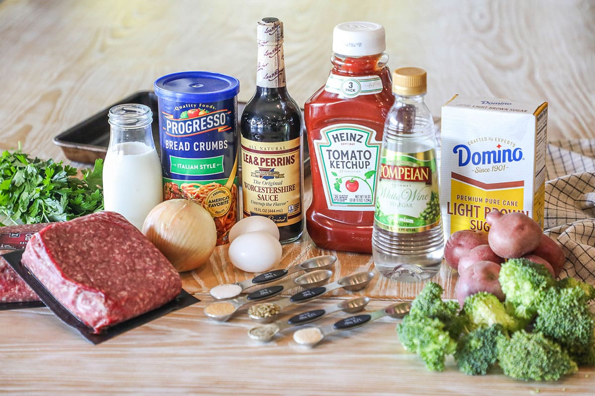 Ingredients needed to make Mini Meatloaf Sheet Pan Dinner. On a wooden background