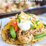 Baked chicken fajitas on a plate, topped with a dollop of sour cream