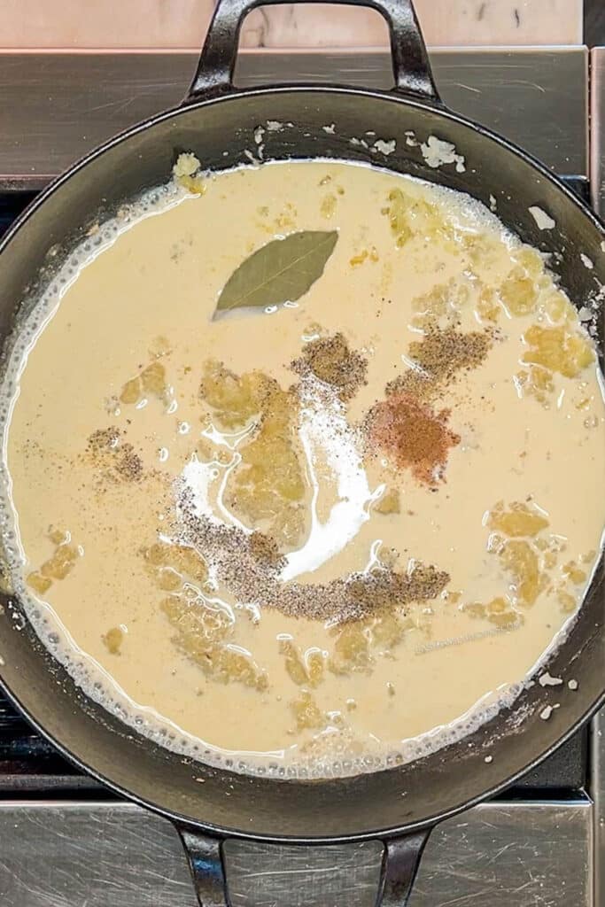 Ingredients for creamed spinach sauce in skillet.