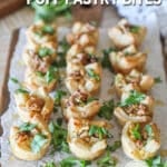 Pear and Gorgonzola Puff Pastry Bites with chopped arugula- on a wooden board- on a wooden background