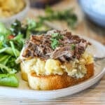 Crockpot beef manhattan on plate with salad.