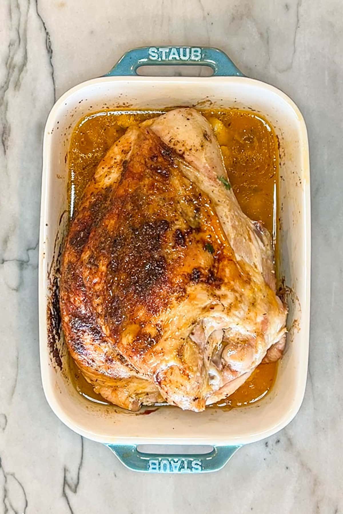 finished oven roasted turkey breast in a baking dish.