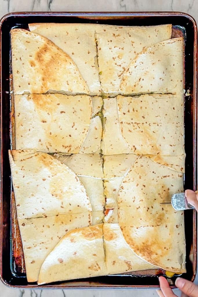 Cutting sheet pan crunch wrap supremes.