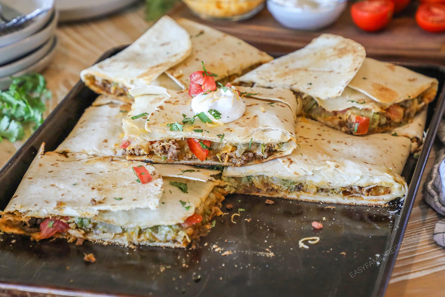 Sheet pan crunch wrap supremes piled on pan.