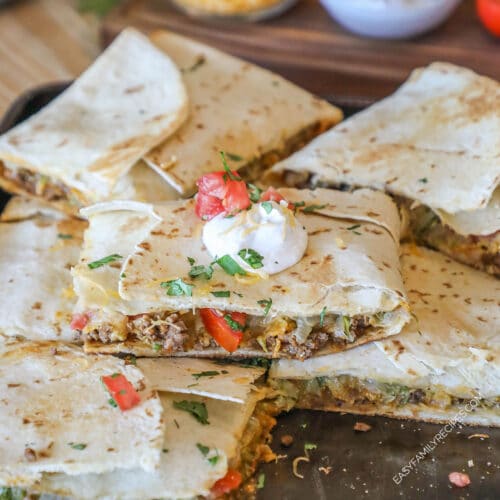 Sheet pan crunch wrap supremes stacked on pan.