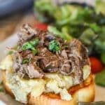 Crockpot beef manhattan on plate with salad.